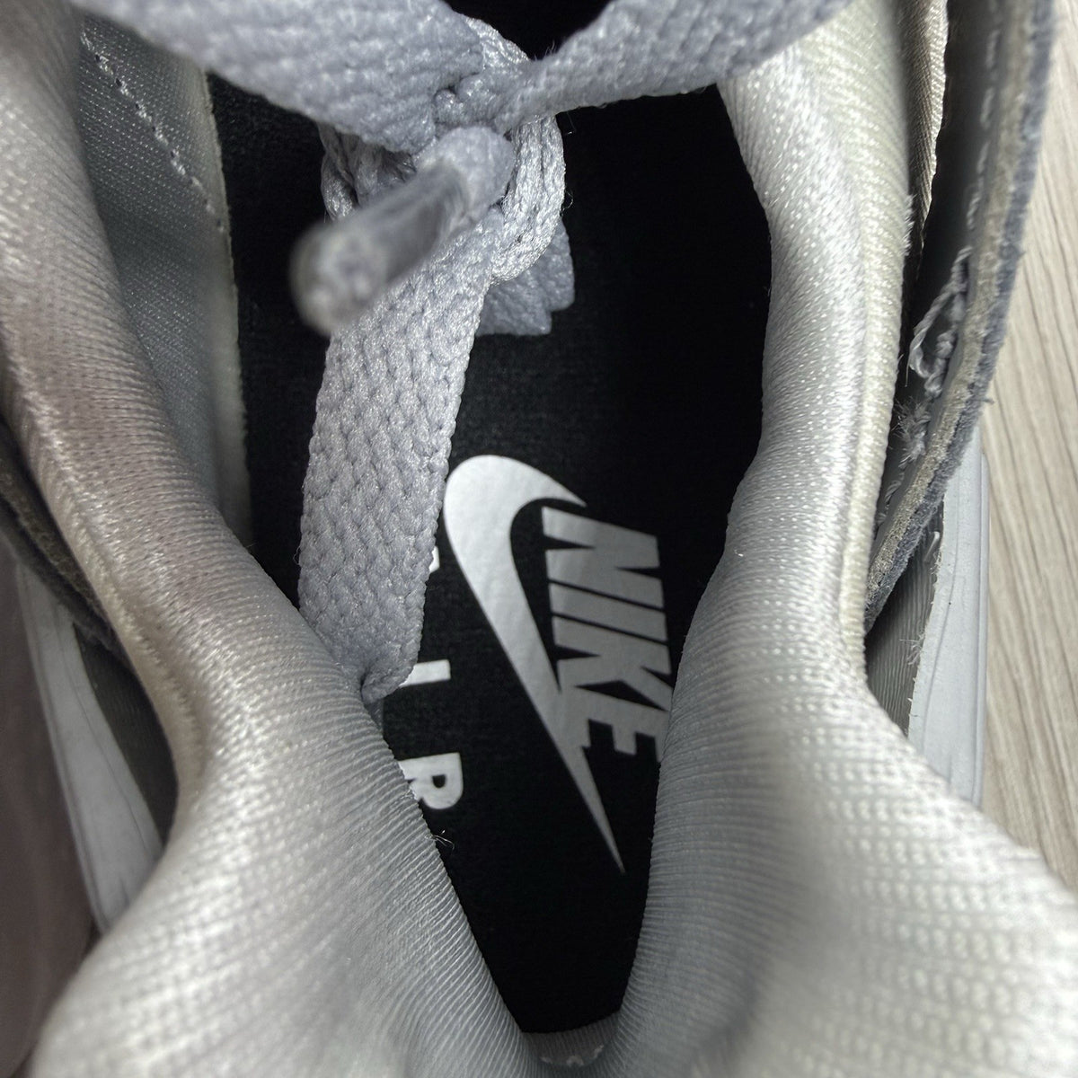 Nike white trainers with grey accents and signature logo on the tongue.
