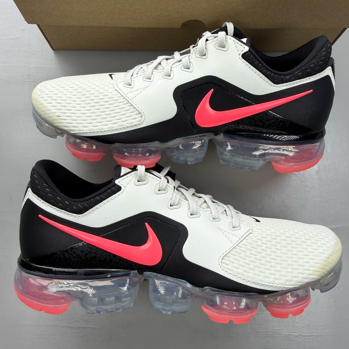 Nike Air VaporMax CS white trainers with mesh upper and vibrant Hot Punch accents.