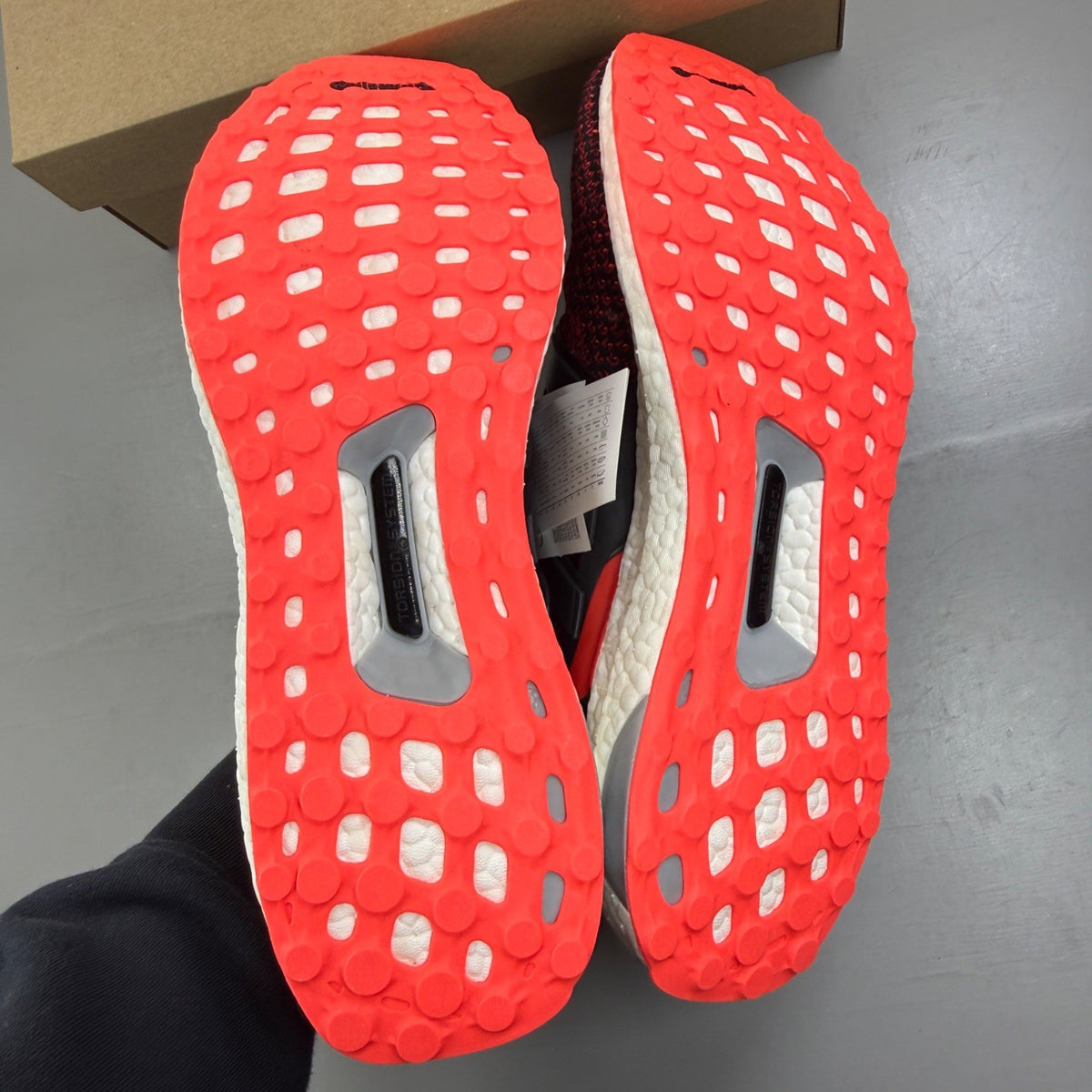 Adidas Ultra Boost 2.0 red trainers with black accents and signature three-stripe logo.