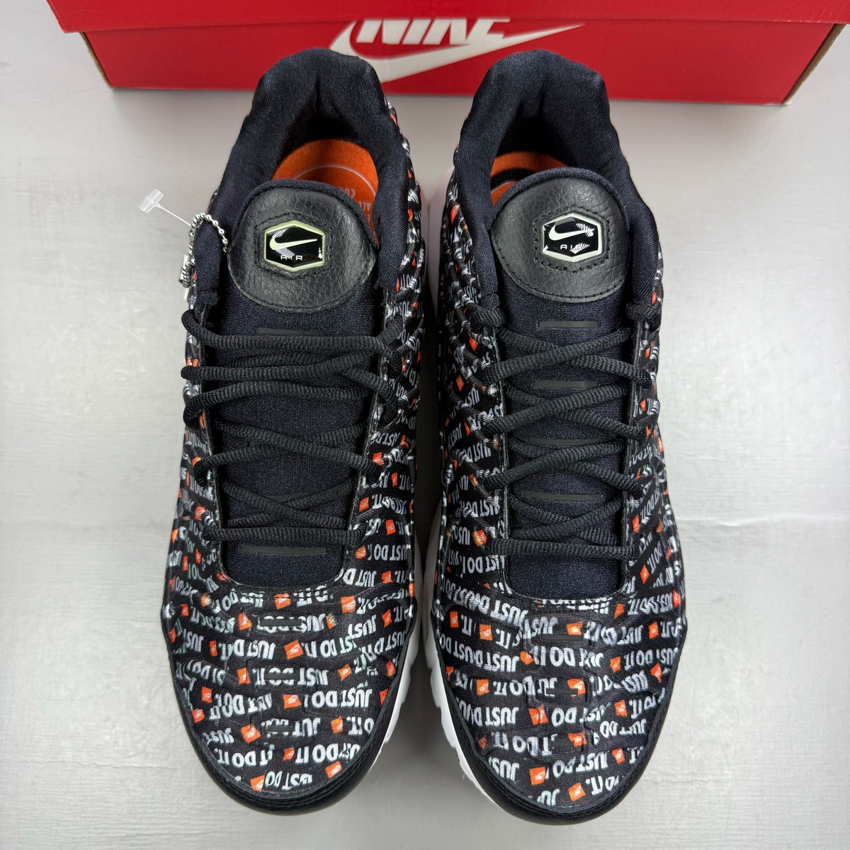 Nike black trainers featuring the Just Do It logo and sleek design.