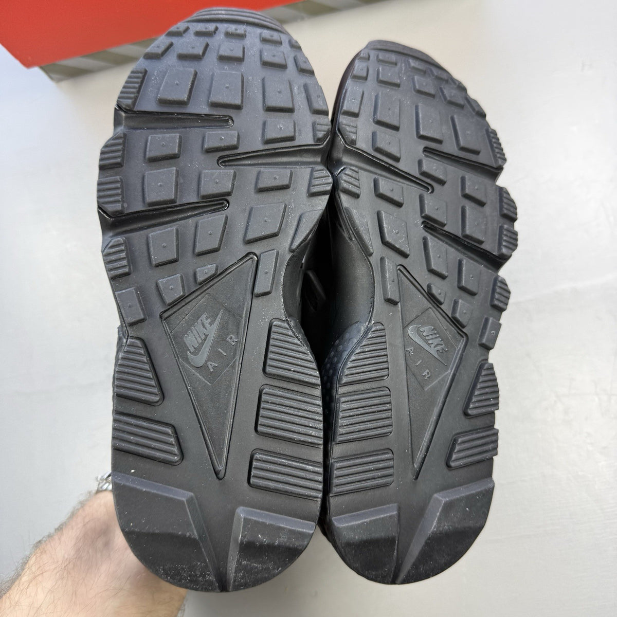 Nike black Air Huarache trainers with anthracite heel tab and distinctive design.
