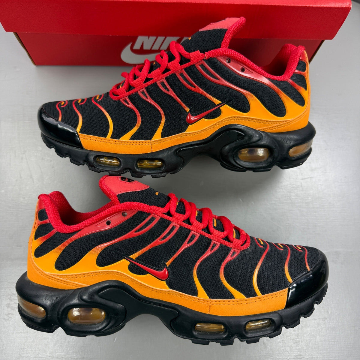 Nike black Air Max Plus TN trainers with red and orange accents and signature logo.