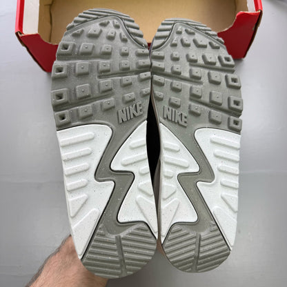 Nike Air Max 90 PRM grey trainers with white accents and distinctive logo details.