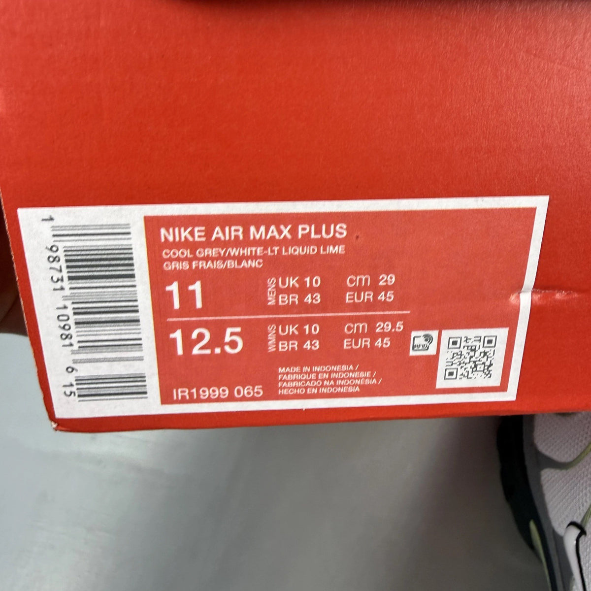 Nike Air Max Plus TN grey trainers with white and liquid lime accents, logo detail.