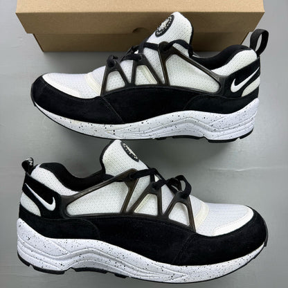 Nike black Air Huarache Light trainers with white accents and mesh detailing.