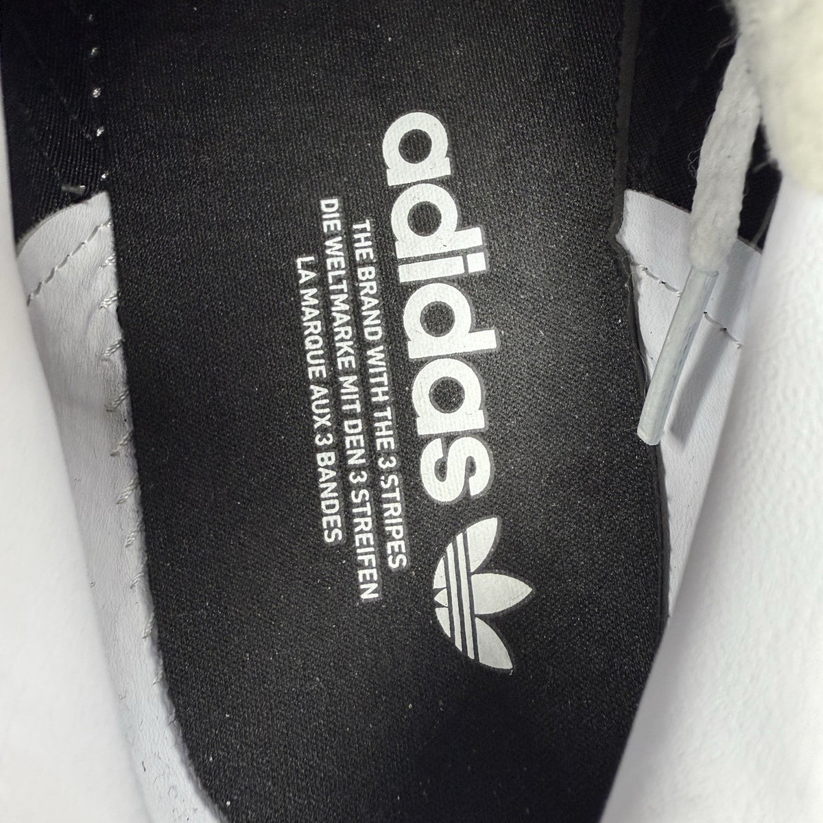 Adidas Gazelle Bold black trainers with white stripes and logo detailing.
