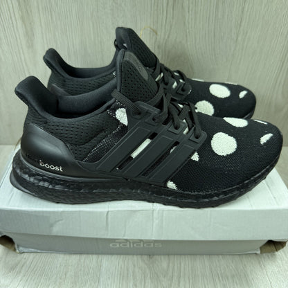 Adidas black trainers with white polka dot pattern and iconic three-stripe logo.