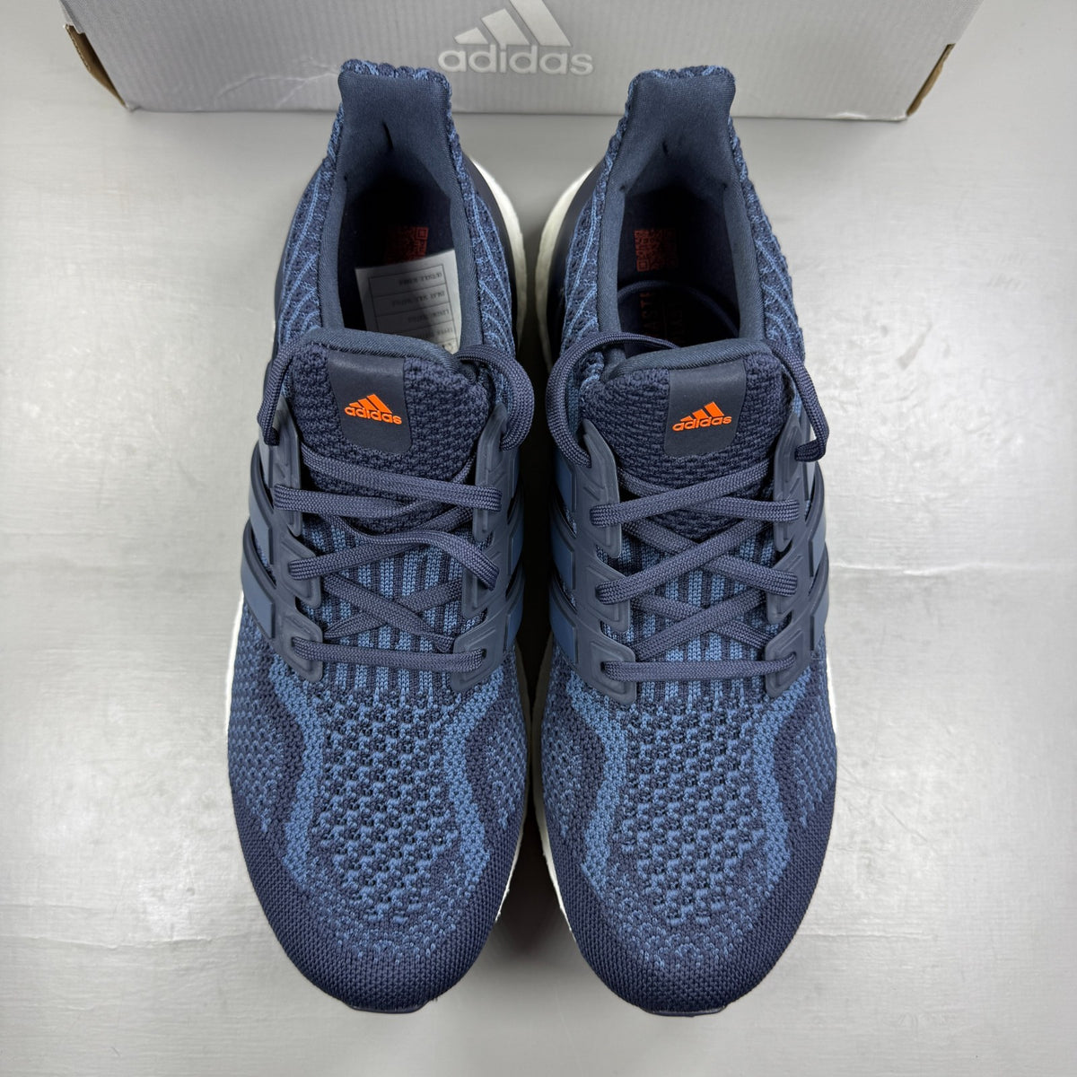 Adidas running shoes blue with Boost cushioning and iconic three-stripe logo.