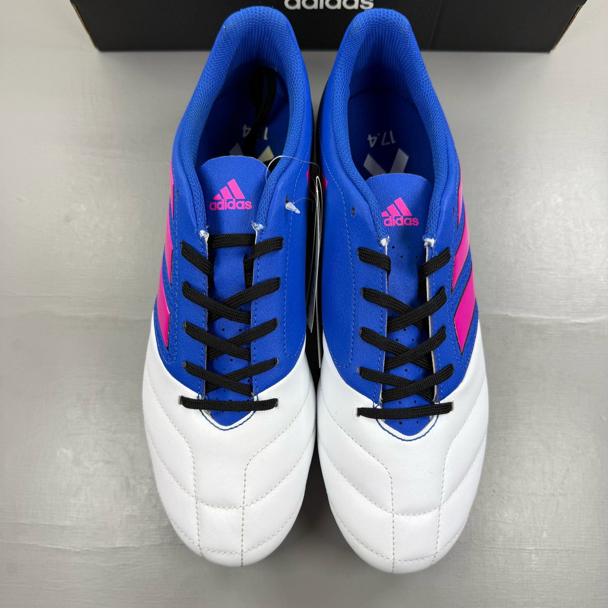 Adidas football boots white with blue and pink accents, featuring logo and textured material.