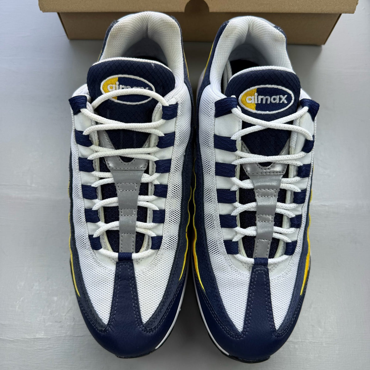 Nike Air Max 95 trainers white with navy and yellow accents, featuring logo on tongue.