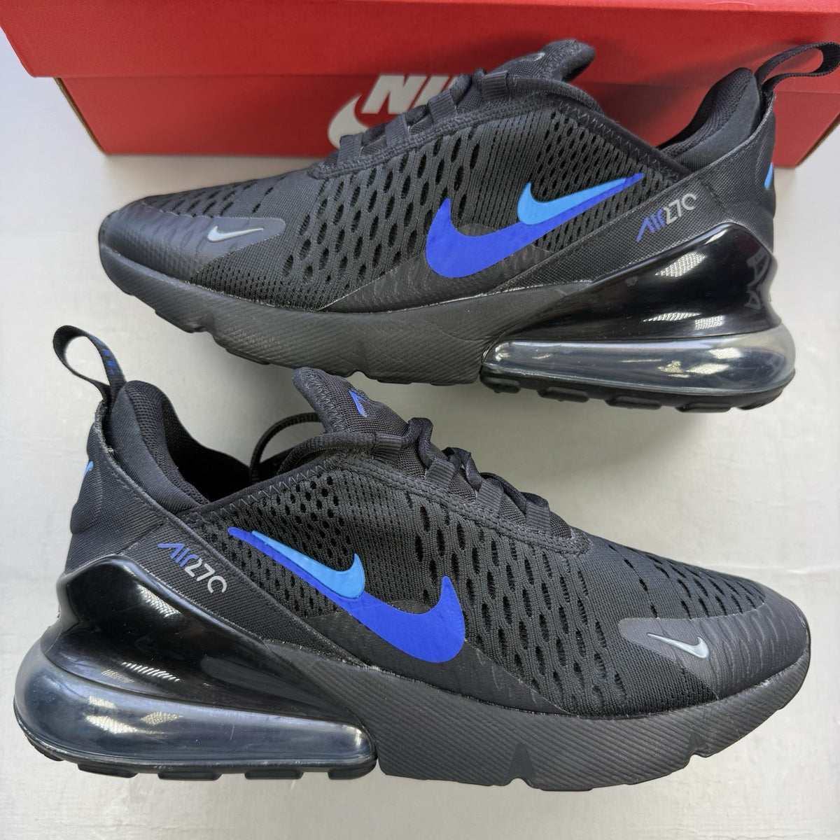 Nike black Air Max 270 trainers with Hyper Royal Blue accents and 'Just Do It' branding.