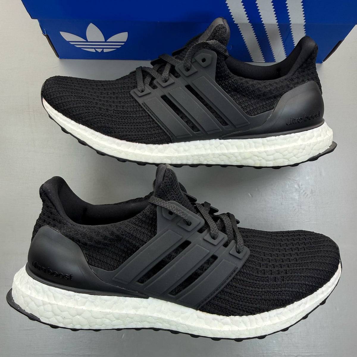 Adidas Ultra Boost 4.0 black running trainers with white accents and logo detail.