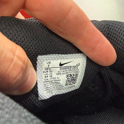 Nike black trainers with metallic silver swoosh logo and sleek design.