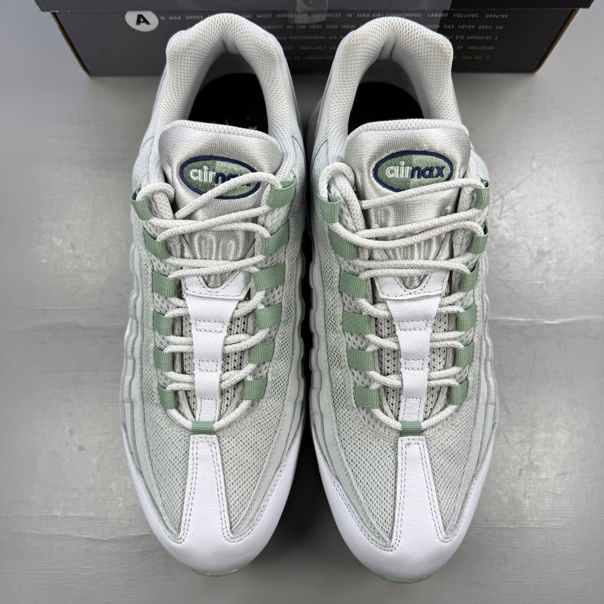 Nike running shoes white with green accents and distinctive Air Max cushioning.