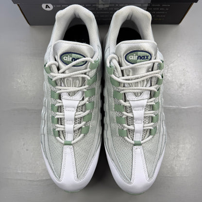 Nike running shoes white with green accents and distinctive Air Max cushioning.