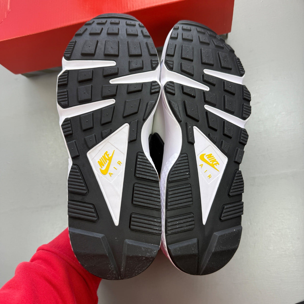 Nike athletic shoes white with yellow maize and navy accents, featuring iconic Huarache design.