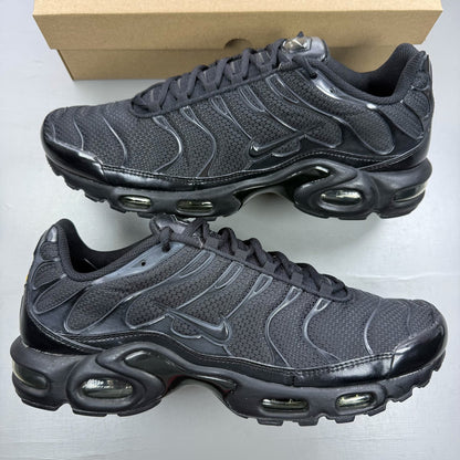 Nike Air Max Plus TN black trainers with distinctive wave pattern and logo detail.