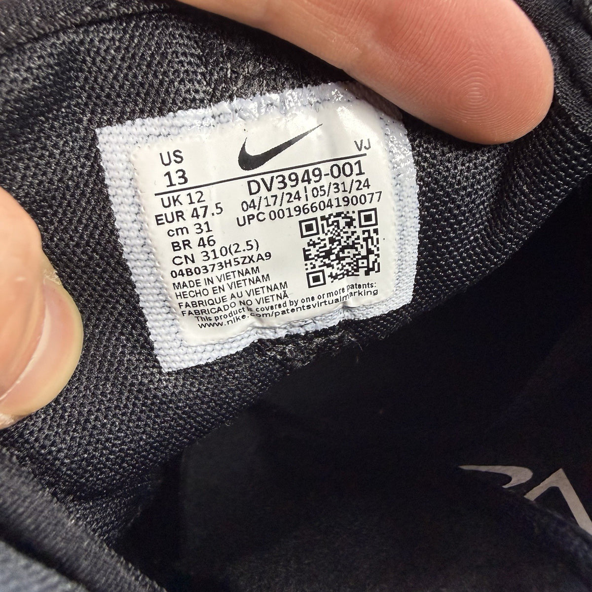 Nike black trainers with white and anthracite accents, featuring a sleek design and logo.