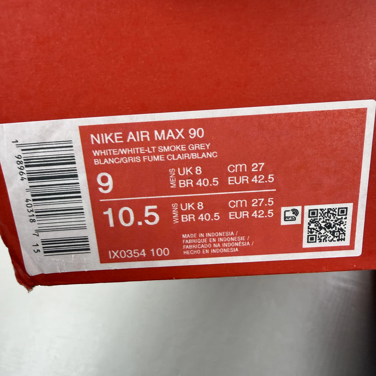 Nike Air Max 90 white trainers with light smoke grey and blue accents, logo on tongue.