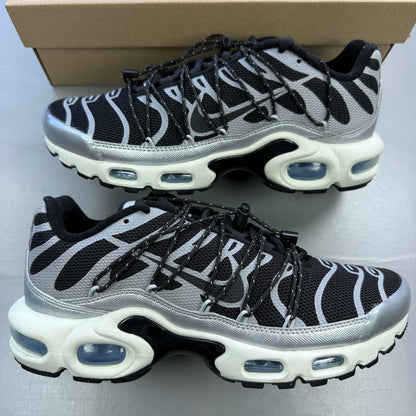 Nike black trainers with silver accents and toggle lacing system.