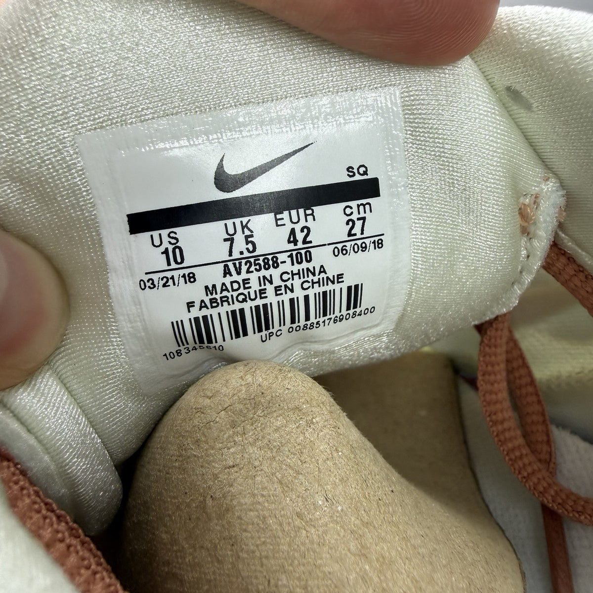 Nike Air Max Plus TN white trainers with peach accents and signature swoosh logo.