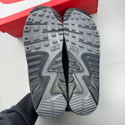 Nike black trainers with grey accents and Air Max cushioning detail.