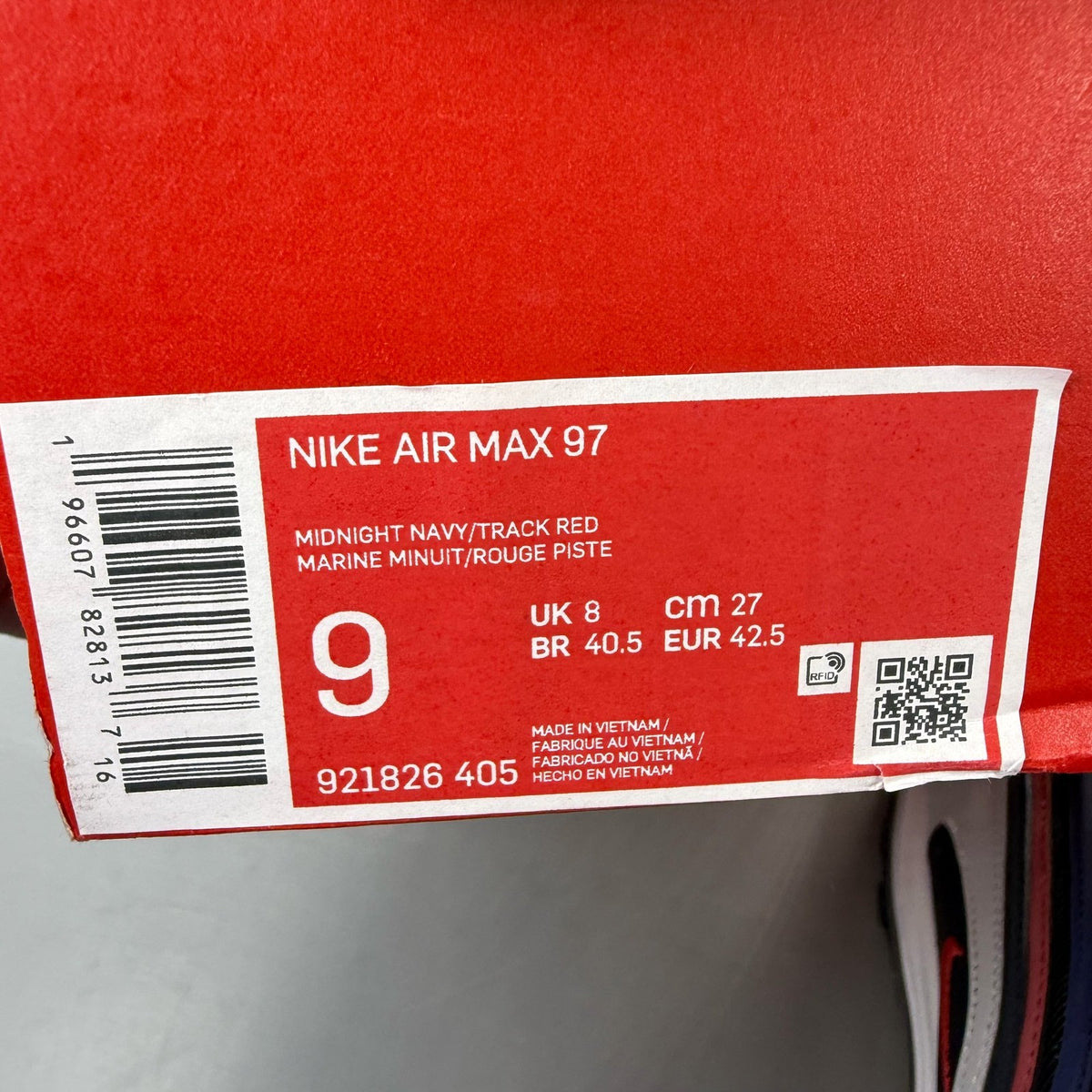 Nike Air Max 97 blue trainers with red accents and iconic logo detailing.
