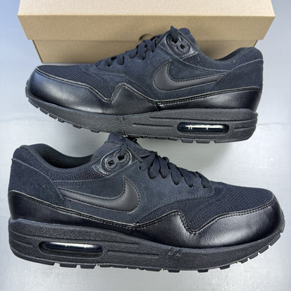 Nike black Air Max 1 Essential trainers with signature swoosh logo and mesh detailing.