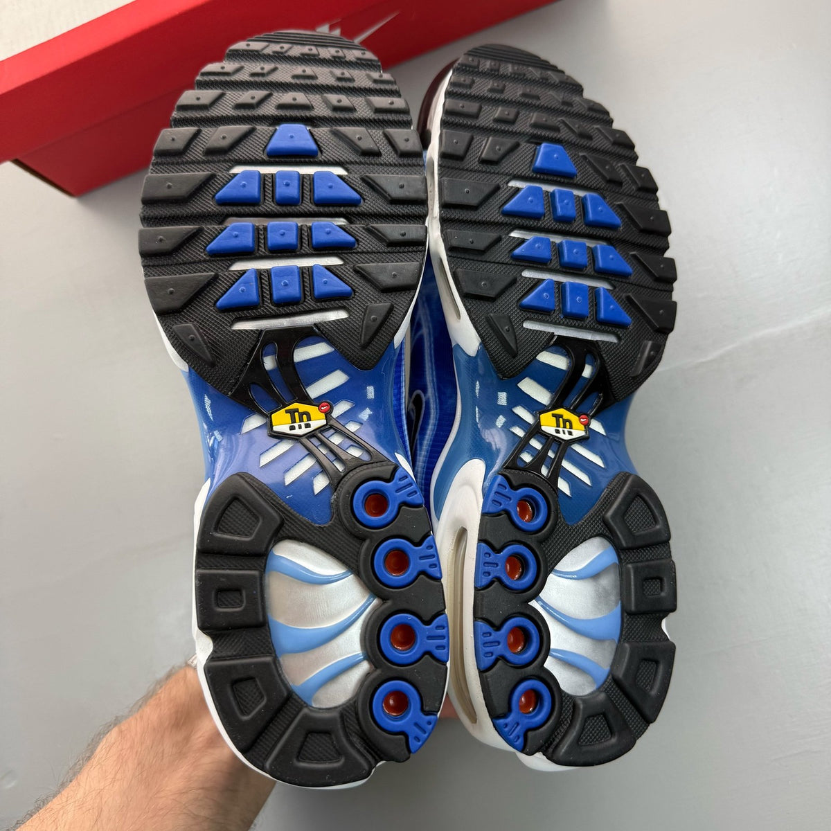 Nike Air Max Plus TN blue trainers with distinctive wave pattern and logo.