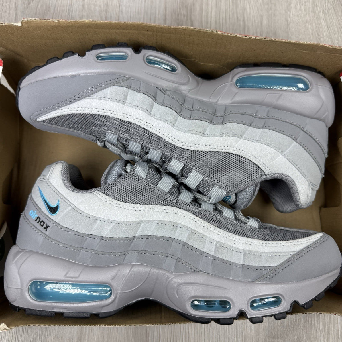 Nike Air Max 95 trainers grey with aqua blue accents and retro logo details.