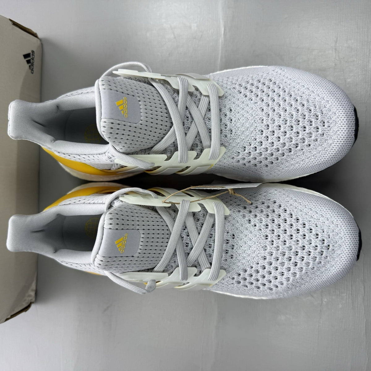 Adidas Ultra Boost 1.0 grey trainers with bold gold accents and white sole.