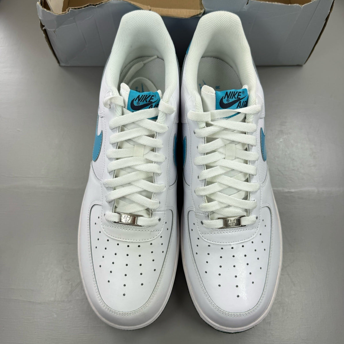Nike Air Force 1 trainers white with marina blue and dark obsidian accents.