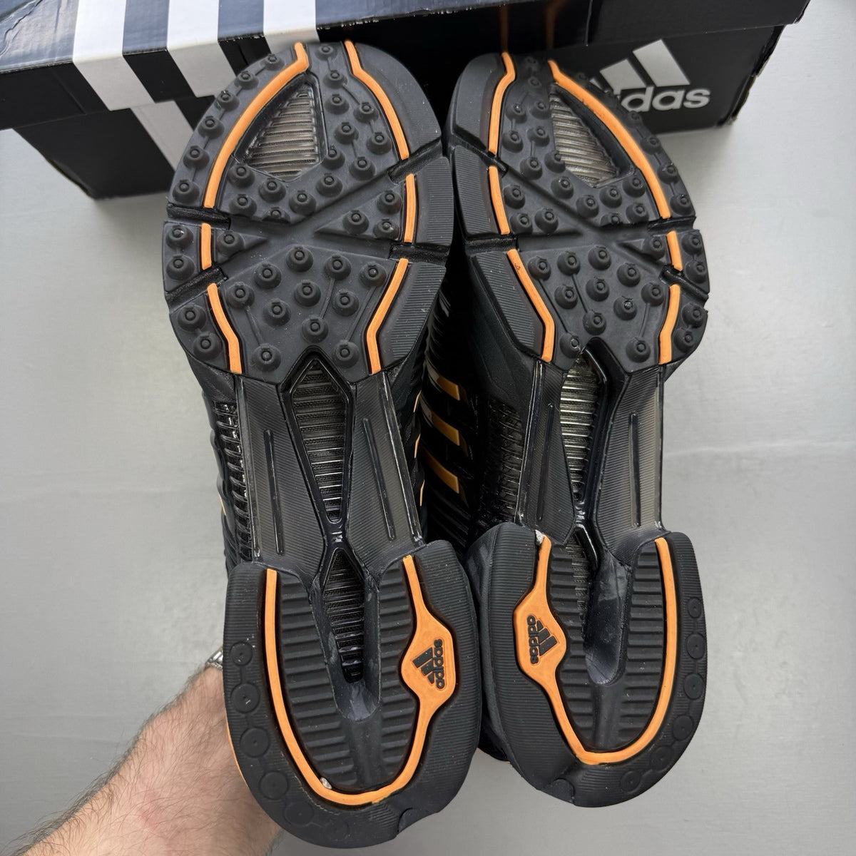 Adidas black trainers with flash orange accents and Climacool ventilation design.