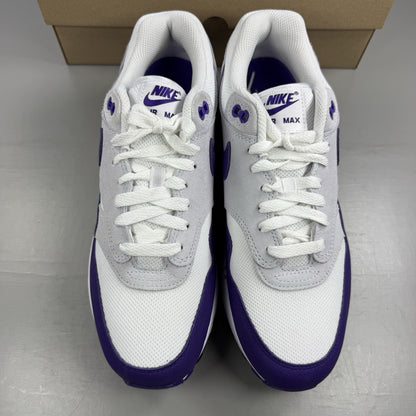 Nike Air Max 1 SC white trainers with purple and black accents, featuring logo detail.