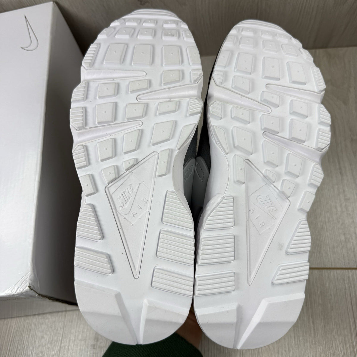 Nike white trainers with grey accents and signature logo on the tongue.