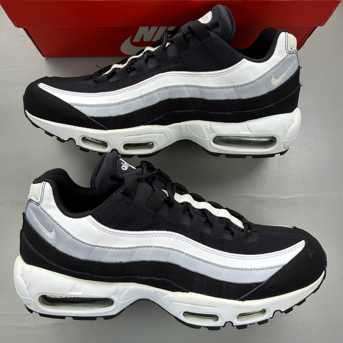 Nike Air Max 95 black trainers with grey and white accents, featuring iconic logo.