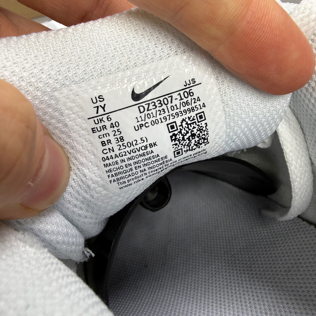 Nike Air Max 1 white trainers with black and grey accents, featuring logo details.