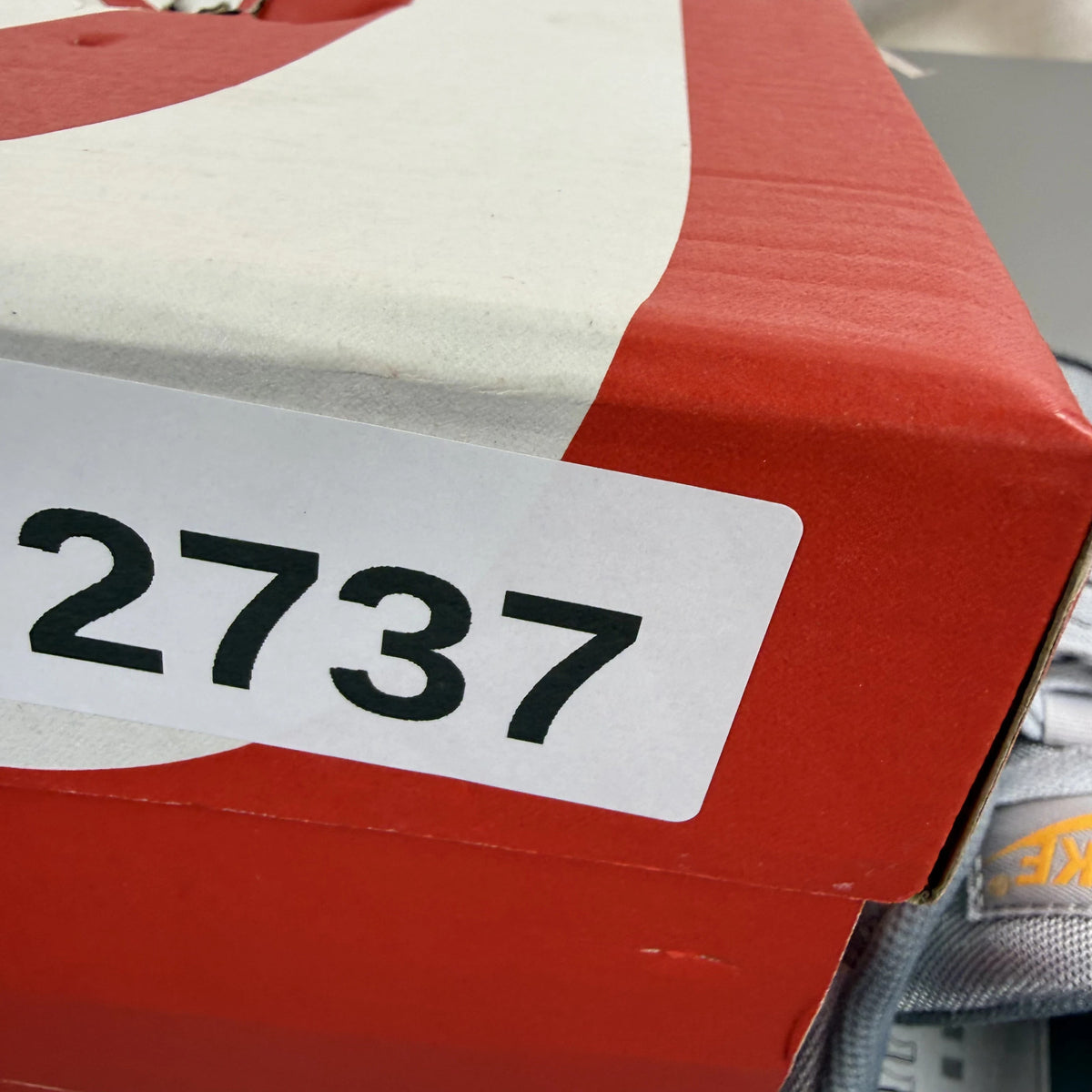 Nike Air Max 90 grey trainers with black and sundial accents, featuring logo details.