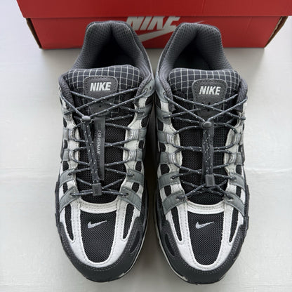 Nike black trainers with grey accents and reflective detailing, featuring a classic logo.