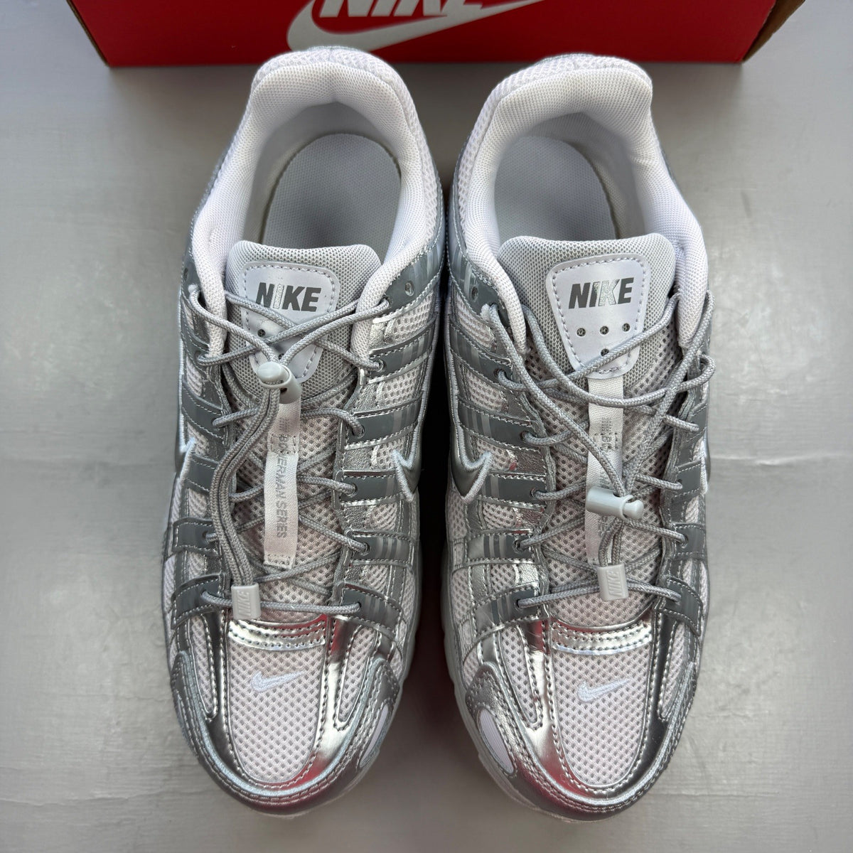 Nike deck shoes silver with logo details and sleek design.