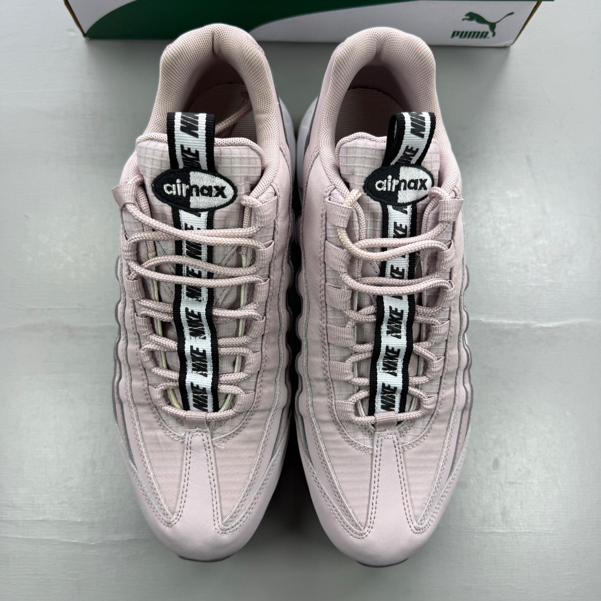 Nike trainers pink with white accents and Air Max cushioning details.