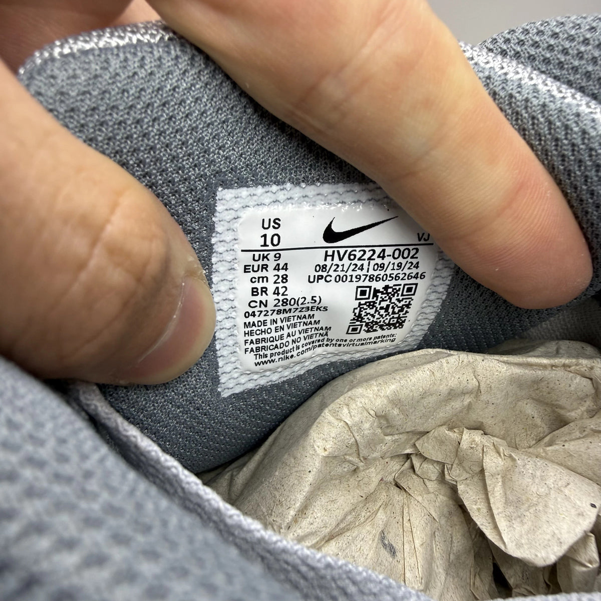Nike Air Max 90 grey trainers with black and sundial accents, featuring logo details.