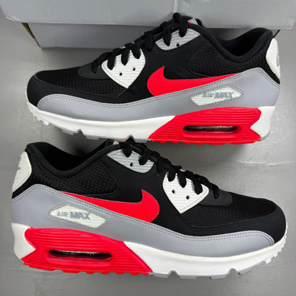 Nike Air Max 90 black sneakers with bright crimson accents and logo detailing.