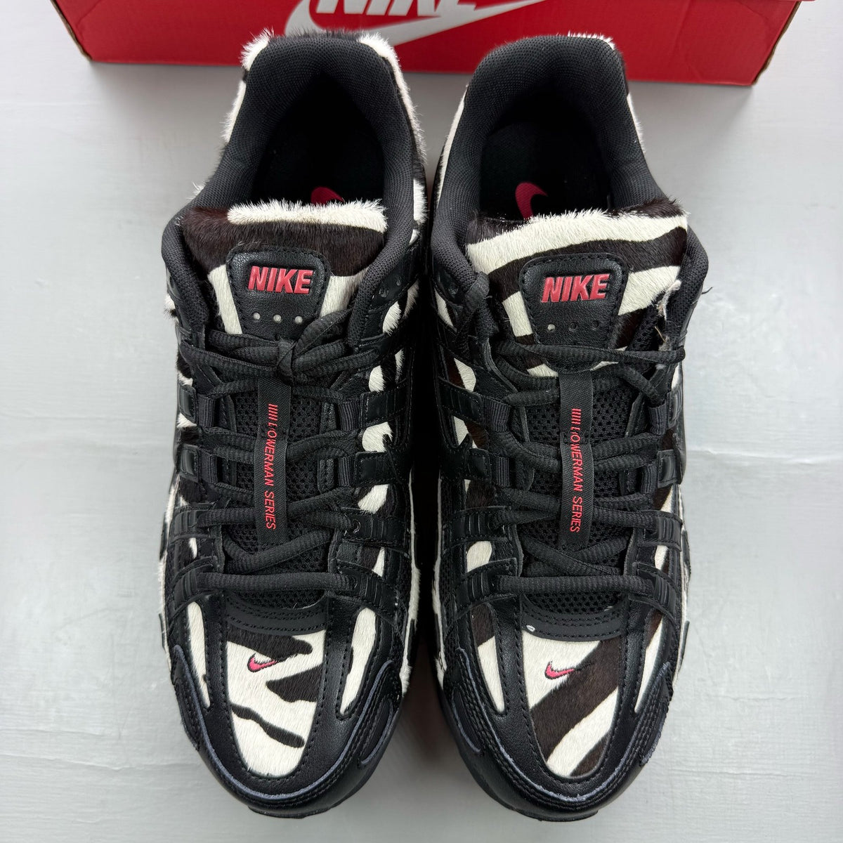 Nike black trainers zebra print design with solar red accents and white detailing.
