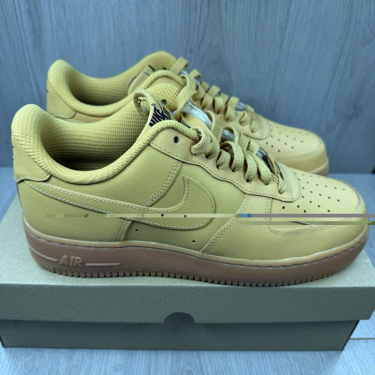 Nike Air Force 1 trainers brown suede upper with gum sole and logo detail.