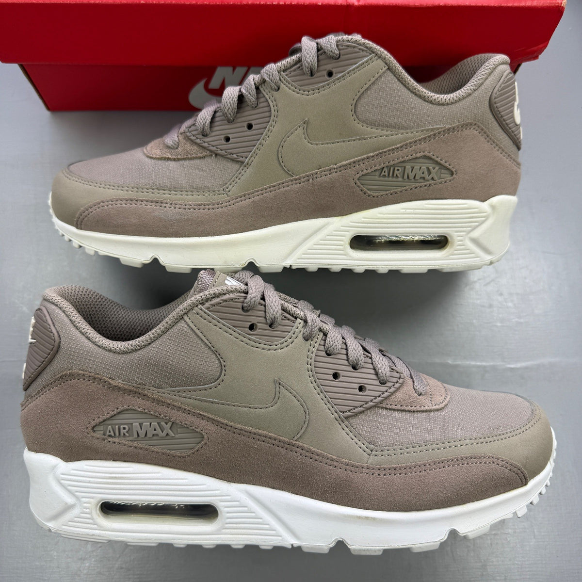 Nike beige trainers with Air Max cushioning and logo detailing.