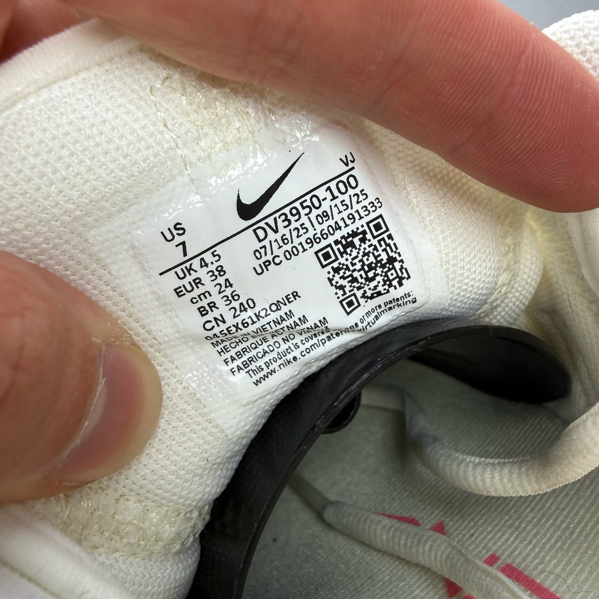 Nike white trainers with mesh upper and subtle branding details.