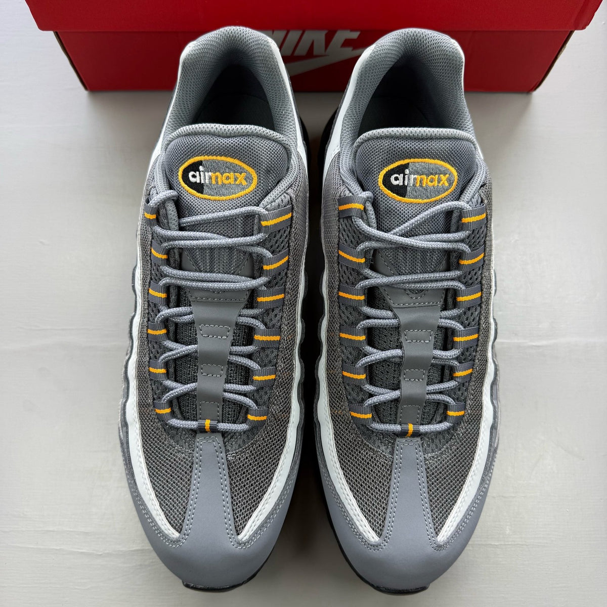 Nike Air Max 95 grey trainers with sundial accents and mesh material.