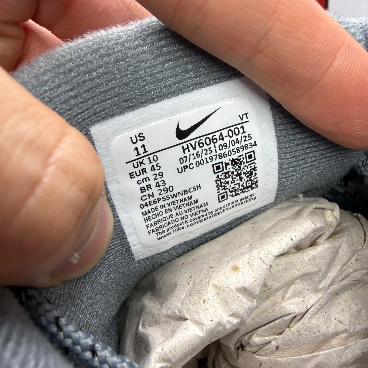 Nike Air Max 95 grey trainers with caution strip detailing and black accents.