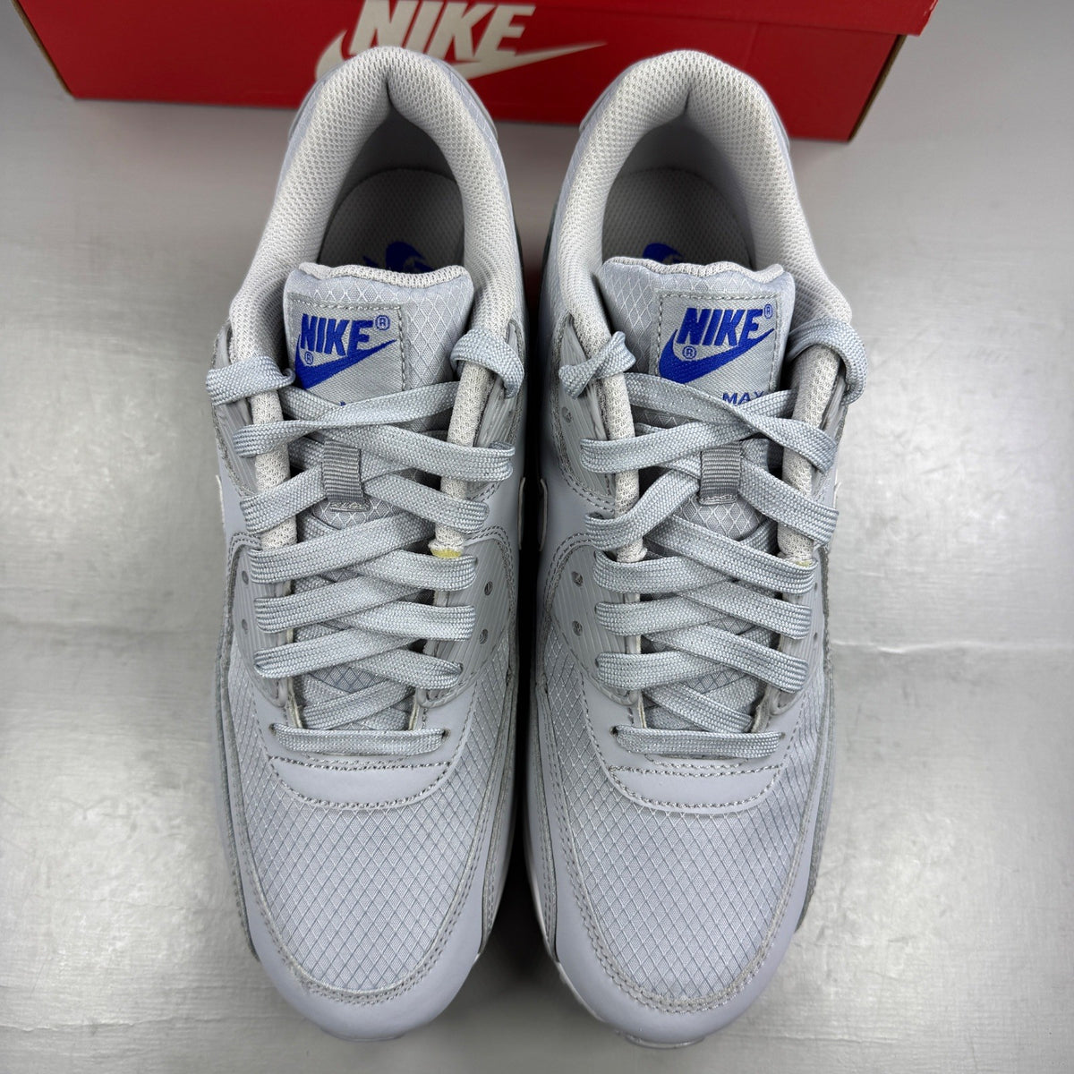 Nike running shoes grey mesh upper with white accents and signature swoosh logo.